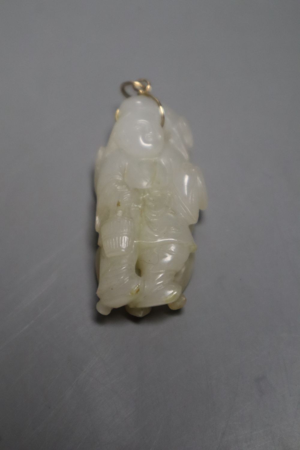 A Chinese pale celadon and russet jade figure of a boy, 4.8cm, a similar carved pendant together with a yellow metal and hardstone set